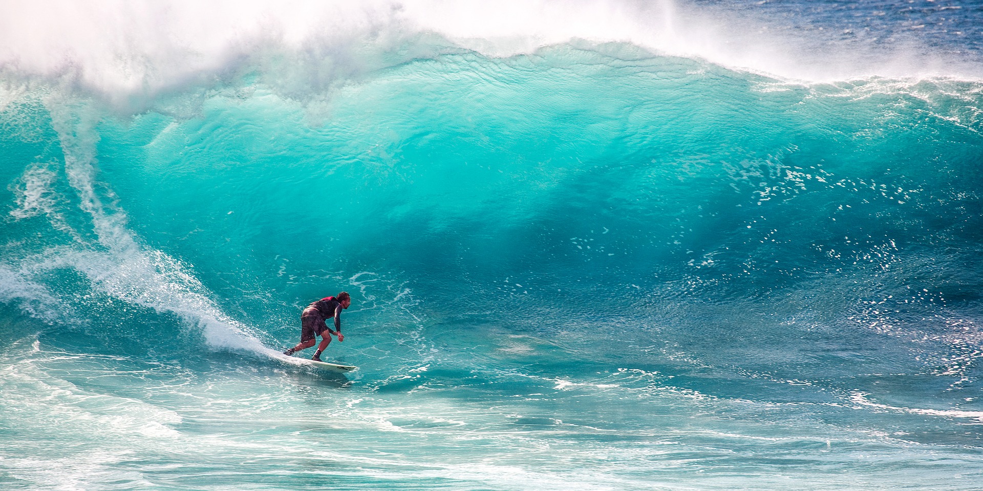 美しいハワイの海でサーフィンを楽しんでいる男性