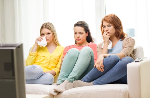 テレビを見ながら涙を流している女性たちの様子